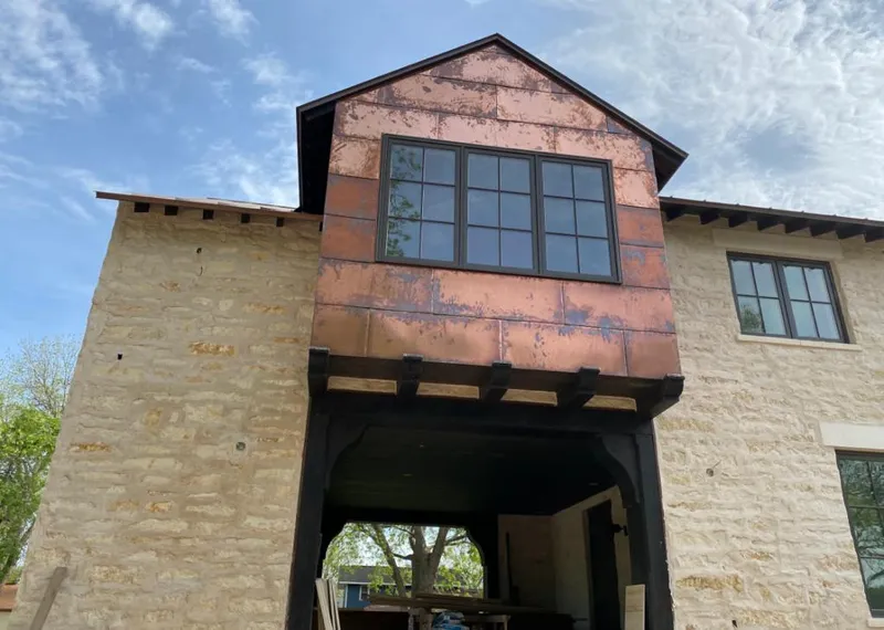 Copper metal panel facade on a stone building for Skylight Installation in Clover Creek